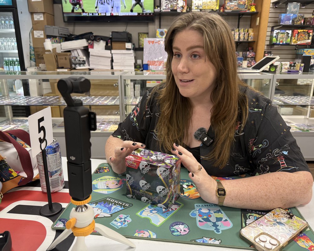 Bry filming a Pokémon TCG unboxing on location at a card shop